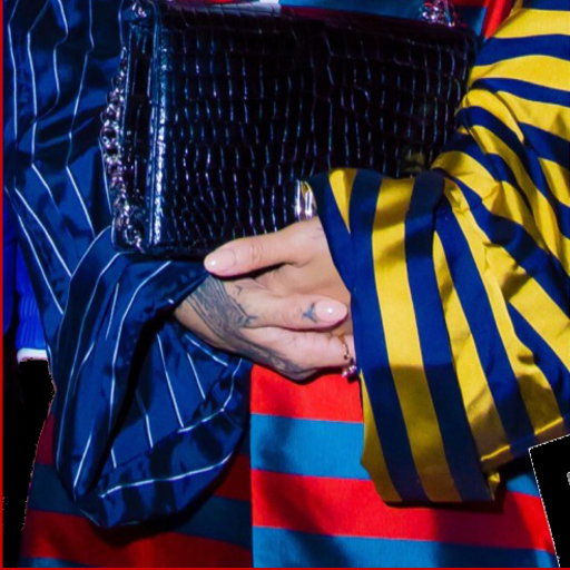 A-close-up-image-of-Rihanna's-hands-buried-in-a-large-amount-of-loose-striped-fabric